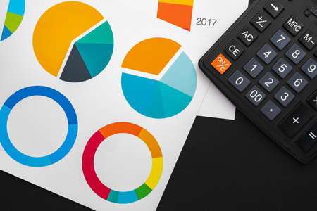 Business graphs paper and calculator on tableの写真素材