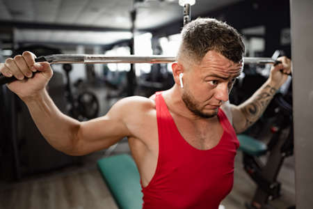 Portrait of man bodybuilder in red shirt in gymの写真素材