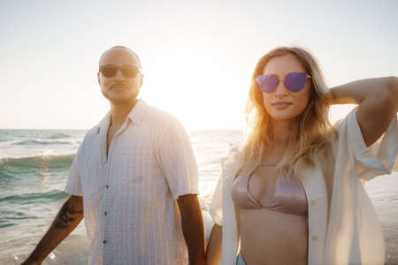 Young beautiful couple walking on beach near seaの写真素材