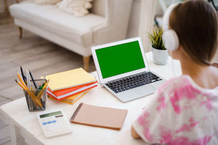 Young girl using laptop for homework at home