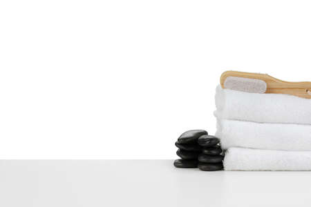 Spa still life with stacked of stone and towel isolated on whiteの写真素材