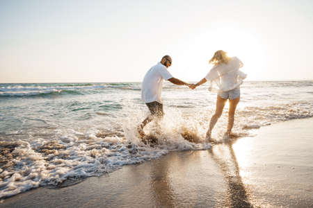 Young beautiful couple walking on beach near seaの写真素材