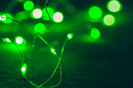 Bokeh of green garland lighting elements backgroundの写真素材