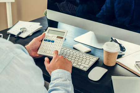 Young man businessman sitting at his working table in office