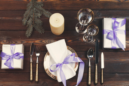 Holiday table setting on wooden table in lilac colors