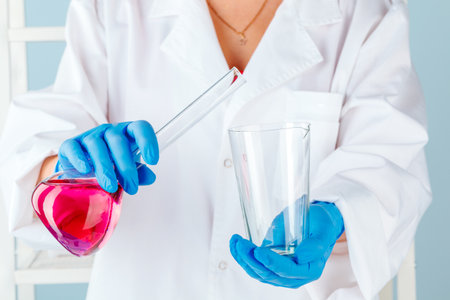 Chemist hands holding test tubes with liquids and doing experiments