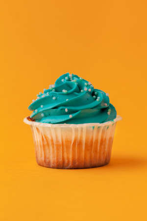 Delicious cupcakes with icing on a yellow backgroundの写真素材