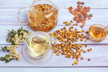 Healthy chamomile tea in glass cup. Teapot, small honey jarの写真素材