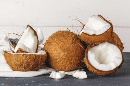 Pile of broken coconuts on ripped grey background