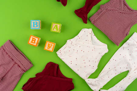Top view of baby clothes on green backgroundの写真素材