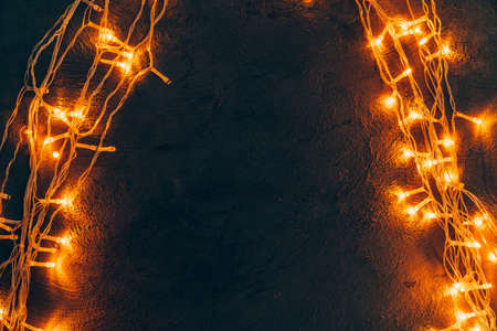 Warm light illuminated garland close up on dark backgroundの写真素材
