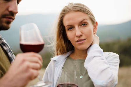 Smiling couple toasting wine glasses outdoors in mountainsの写真素材