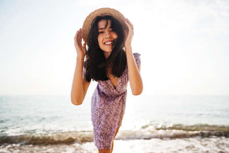 Portrait of young woman walking on the beach on sunriseの写真素材