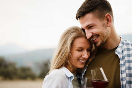 Smiling couple toasting wine glasses outdoors in mountainsの写真素材
