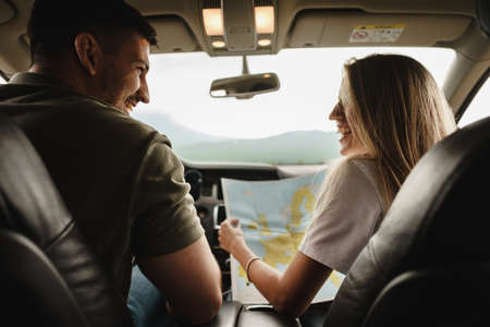 Young loving couple on a road trip using map inside a carの写真素材
