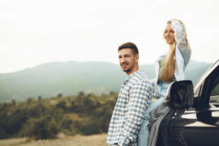 Young couple is on romantic trip to the mountains by carの写真素材