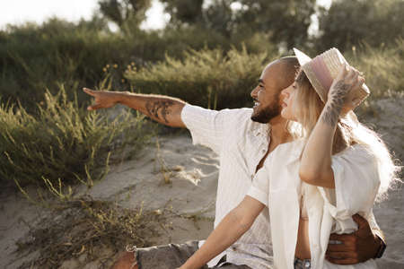 Young couple sitting next to each other on beach