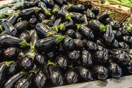 Pile of eggplant for sale on counter in supermarketの写真素材