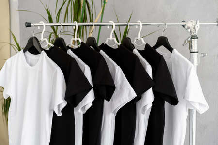 Row of black and white t-shirts hanging on rackの写真素材