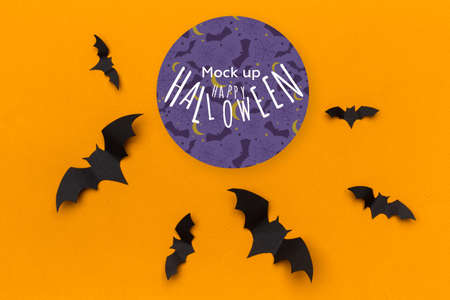 Halloween concept - paper bats on orange background