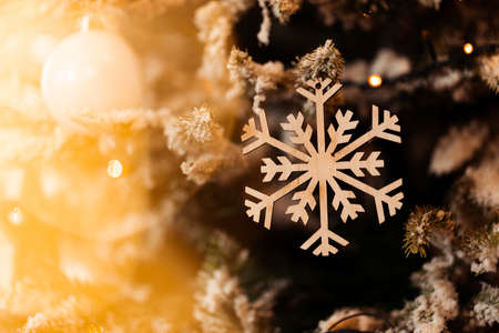 New Years decorative snowflake hanging on a fir-tree branchの写真素材