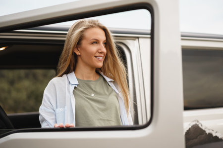 Portrait of happy young caucasian girl posing near off-road carの写真素材