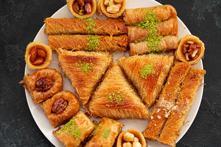 Delicious baklava dessert in oriental setting on black background