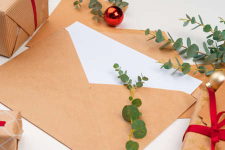 Christmas gift with red bow and greeting card on white wooden background