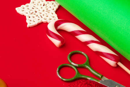 Close up shot of wrapping paper and items for christmas decorating on red background