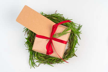 Christmas gift with red bow and greeting card on white wooden backgroundの写真素材