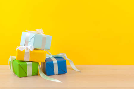 Gifts with ribbons on bright yellow background