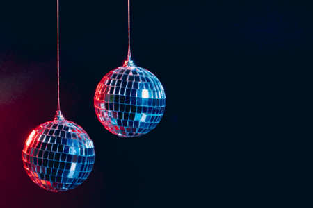Sparkling disco balls hanging in the air against black background
