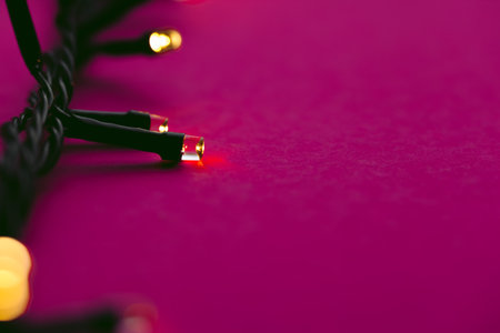 Illuminated garland lights on bright pink backgroundの写真素材
