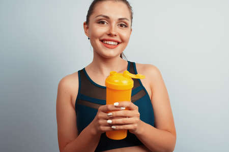 Fit sporty woman holding mineral water bottle in her handの写真素材