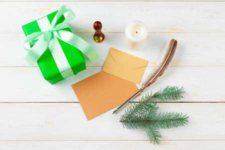 Top view of Christmas letter writing on yellow paper on wooden background with decorationsの写真素材