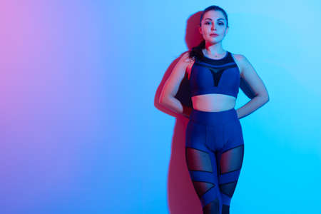 portrait of a young fitness woman in sportswear posing in studio