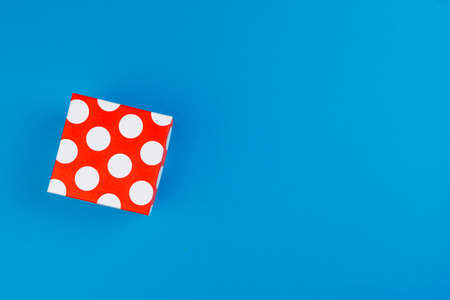 Flat lay of gift box decorated with bow on blue backgroundの写真素材