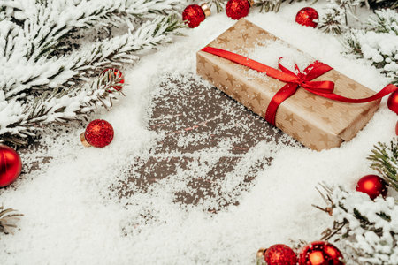 Snowy composition with Christmas gift on wooden tableの写真素材