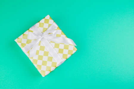 Decorated gift box on a green background, flat lay top viewの写真素材