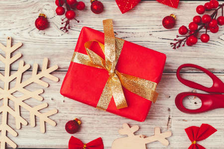 Red Christmas gift with decorations on wooden backgroundの写真素材