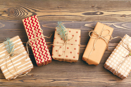 Christmas gifts with fir tree branches on wooden background