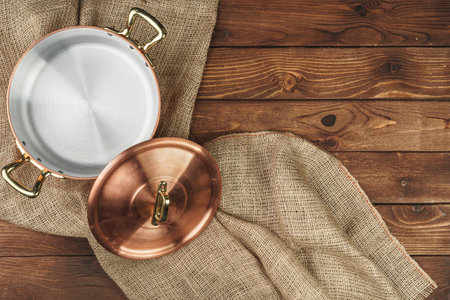 Copper pot on the dark wooden table, top viewの写真素材