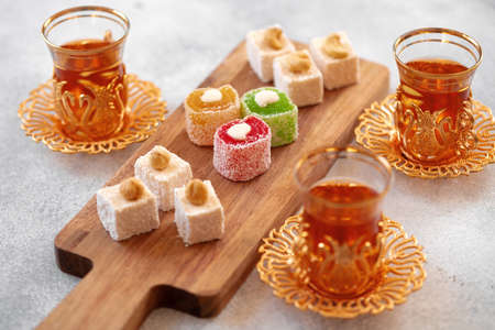 Various Turkish sweets and cup of tea on white textured backgroundの写真素材