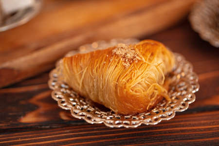 Turkish sweets on small plate on brown wooden background