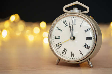 Close up of retro alarm clock on blurred Christmas background with bokeh
