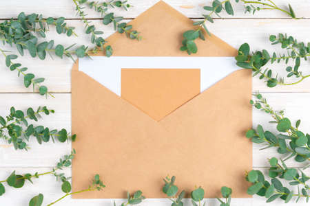 Empty letter with copy space surrounded by floral branches on wooden rustic backgroundの写真素材