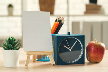 Its time for school. Vintage alarm clock and apple on wooden desk