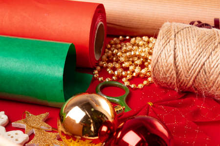 Close up shot of wrapping paper and items for christmas decorating on red backgroundの写真素材