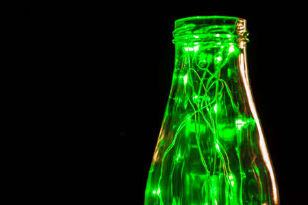 Green garland with light bulbs put in glass storage jarの写真素材