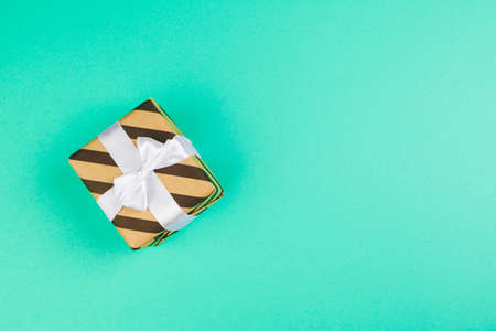 Decorated gift box on a green background, flat lay top viewの写真素材